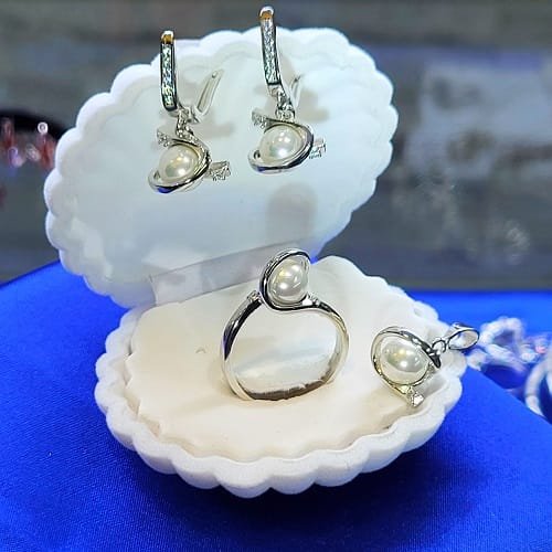 Комплект сребърни бижута с бели перли включва обеци, колие ,висулка и пръстен, изработени с внимание към всеки детайл.Сребро проба 925.