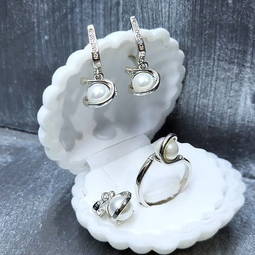 Комплект сребърни бижута с бели перли включва обеци, колие ,висулка и пръстен, изработени с внимание към всеки детайл.Сребро проба 925